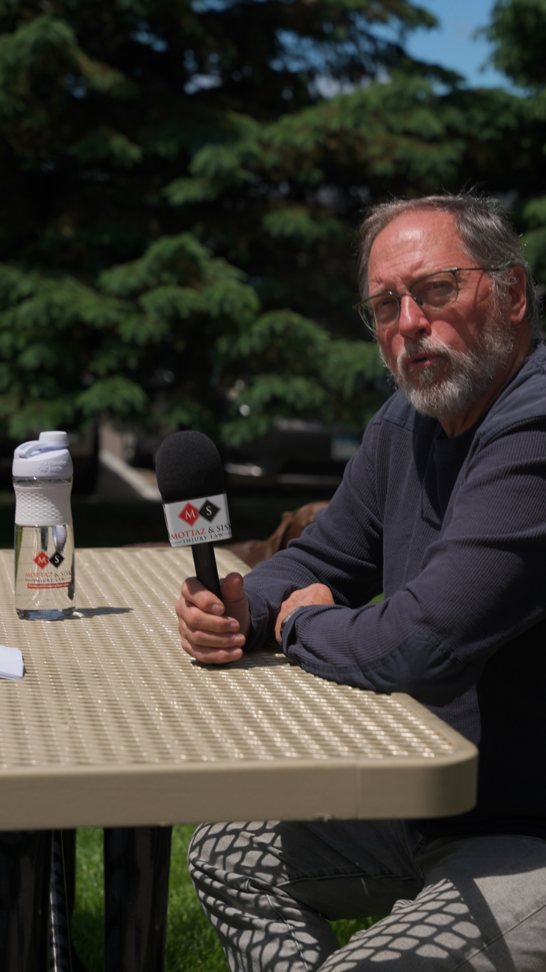 Founder being interviewed with a branded Mottaz & Sisk microphone at an outdoor table