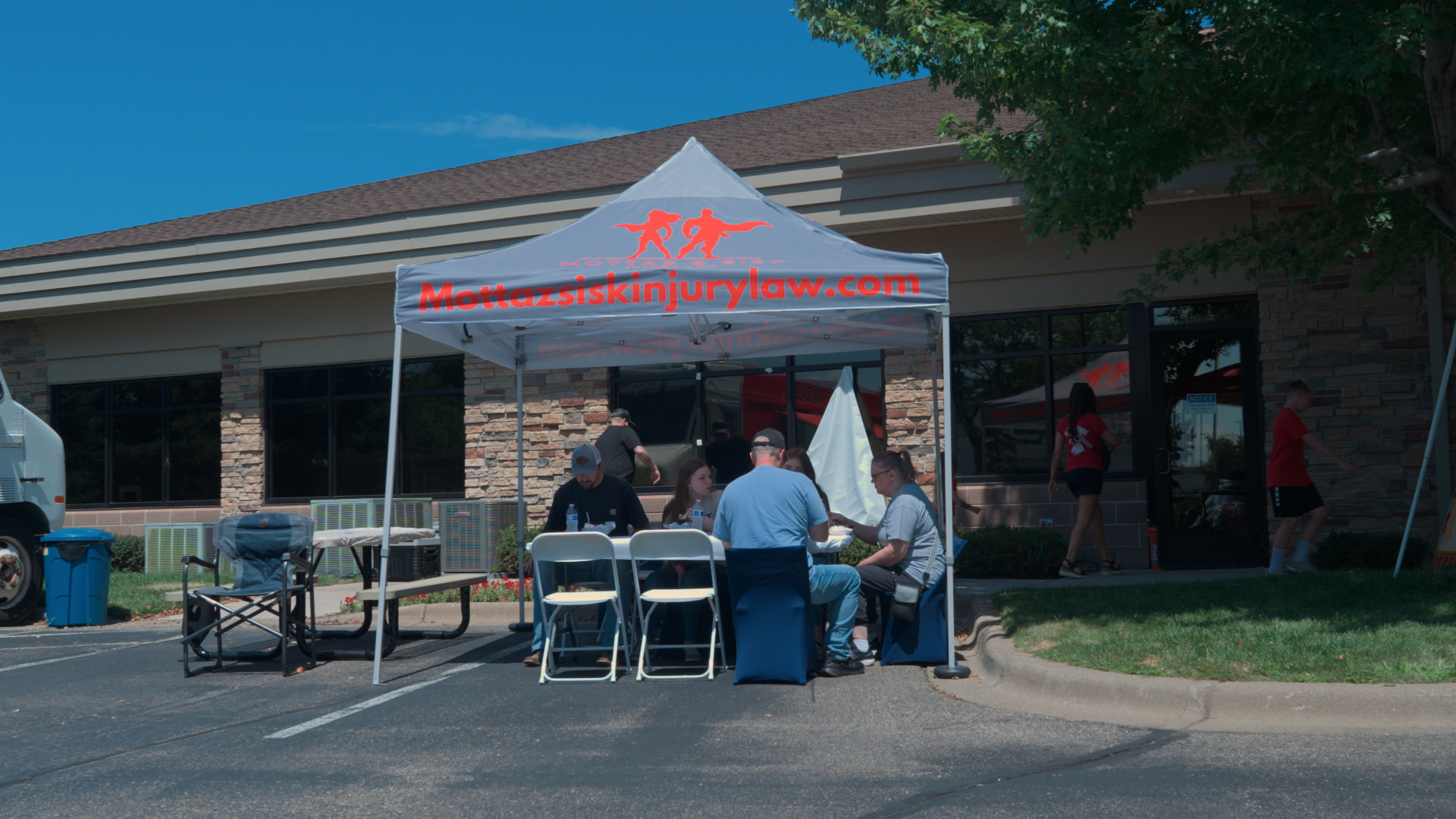 Branded Mottaz & Sisk tent hosting a community event outside the office