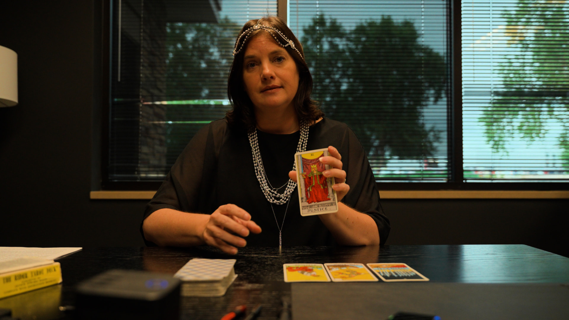 Guest holding up a tarot card during a branded video segment